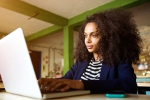 Close up portrait of african american woman using laptop at a cafe